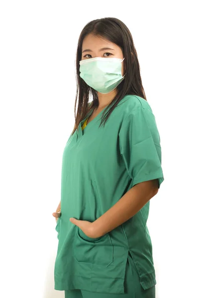 Young beautiful Asian Korean medicine doctor woman or hospital nurse in scrubs using protective medical face mask in prevention against virus infection — 스톡 사진