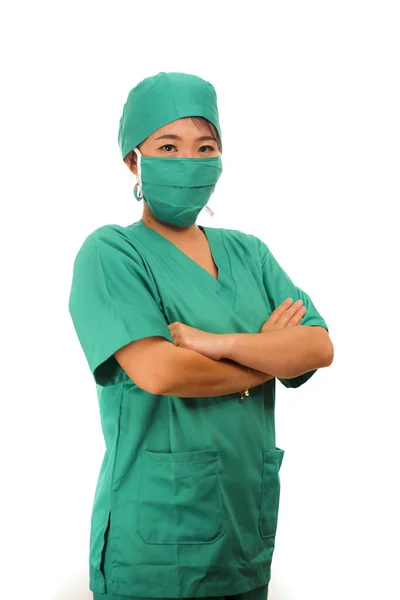 Asian Chinese woman as successful physician - young beautiful and attractive medicine doctor or chief hospital nurse in scrubs and surgeon hat smiling behind surgical mask — 스톡 사진