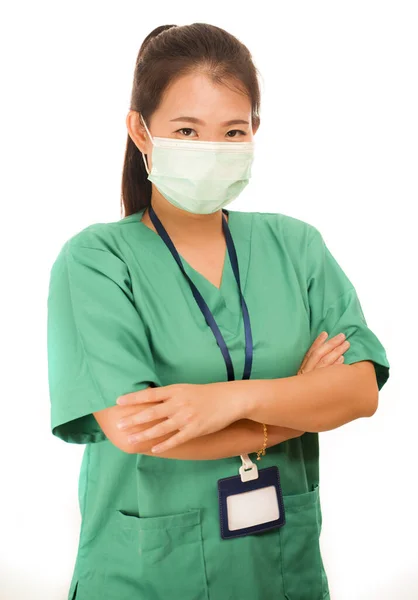 作为成功医生的亚裔中国妇女-年轻美丽而快乐的医生或医院护士长，身穿绿色的刷子，戴着外科面具，双手交叉 — 图库照片