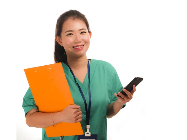 携帯電話を使用して成功した医師としてアジアの韓国人女性-携帯電話を使用して笑顔緑の医療ガウンで若い美しく幸せな医師やチーフ病院看護師 — ストック写真