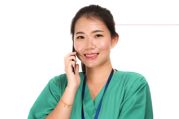 Азиатская китаянка как успешный врач говорит по телефону - молодой красивый и счастливый врач медицины или медсестра в зеленой медицинской форме улыбается — стоковое фото