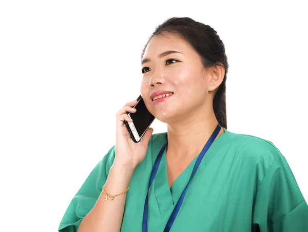 Азиатская кореянка как успешный врач говорит по телефону - молодой красивый и счастливый врач медицины или медсестра в зеленой медицинской форме улыбается — стоковое фото