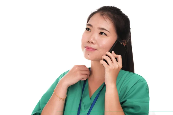 Азиатская китаянка как успешный врач говорит по телефону - молодой красивый и счастливый врач медицины или медсестра в зеленой медицинской форме улыбается — стоковое фото