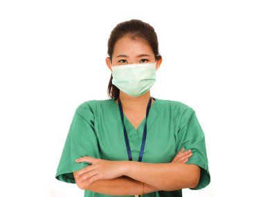 Koreli doktor kadın ya da hastane hemşiresi yeşil önlüklü ve cerrahi koruyucu yüz maskeli virüs salgınından korunmak için