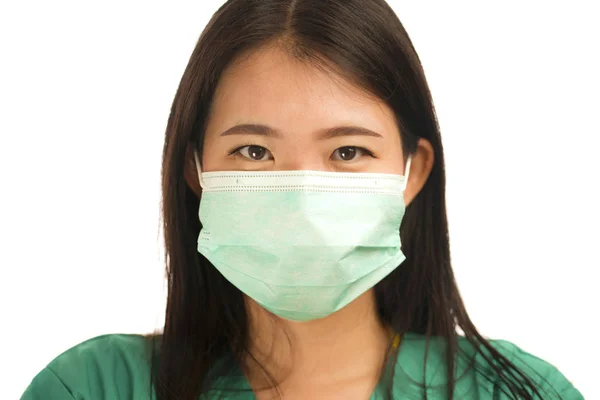 Selbstbewusste asiatische Ärztin oder Krankenschwester in grünem Peeling und chirurgischer Gesichtsmaske zum Schutz vor Virusausbruch — Stockfoto