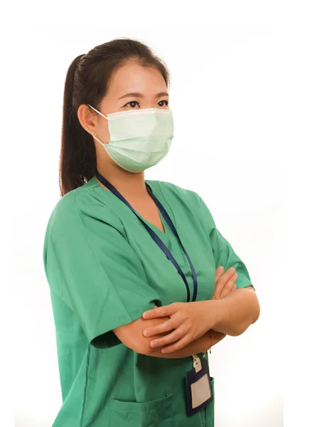 Confident Asian Chinese medicine doctor woman or hospital nurse in green scrubs and surgical protective face mask in protection against virus outbreak concept — 스톡 사진