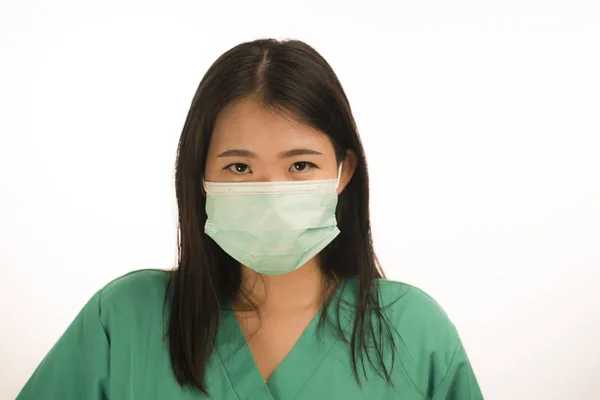 Confident Asian Korean medicine doctor woman or hospital nurse in green scrubs and surgical protective face mask in protection against virus outbreak concept — Stock Photo, Image