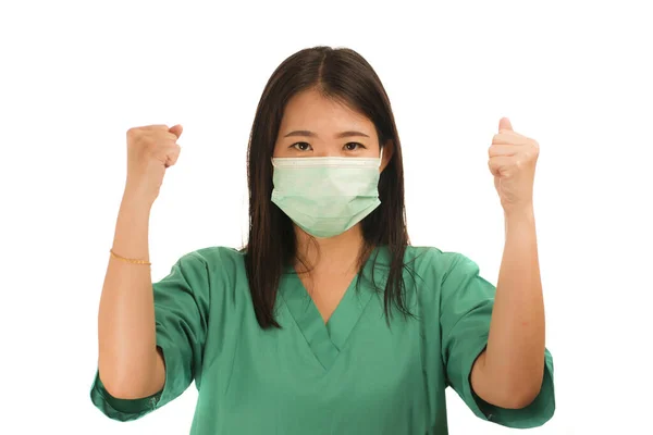 Confident Asian Korean medicine doctor woman or hospital nurse in green scrubs and surgical protective face mask in protection against virus outbreak concept — 스톡 사진