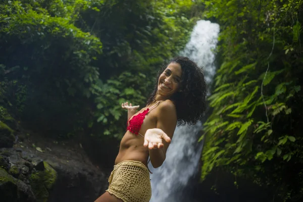 Outdoors tropical lifestyle portrait of young attractive and happy hipster girl enjoying nature excited feeling free at amazing beautiful waterfall in exotic holidays travel — стоковое фото