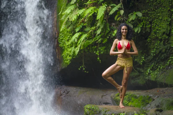 Jeune fille hipster attrayant et heureux faisant du yoga en plein air à la belle cascade tropicale méditant profiter de la liberté et de la nature dans un mode de vie sain et zen — Photo