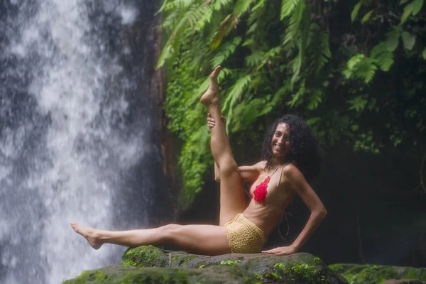Młoda atrakcyjna i szczęśliwa hipsterka uprawiająca jogę na świeżym powietrzu przy pięknym tropikalnym wodospadzie medytująca ciesząca się wolnością i naturą w zdrowym i zen stylu życia — Zdjęcie stockowe
