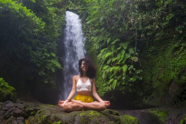 Genç, çekici ve mutlu hippi kadın doğanın tadını çıkarıyor. Egzotik tatil beldelerinde harika bir şelalede özgür hissediyor.