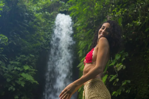 Lifestyleporträt einer jungen attraktiven und glücklichen Hipsterfrau, die die Natur genießt und sich an einem wunderschönen Wasserfall in einem exotischen Urlaubsreiseziel frei fühlt — Stockfoto