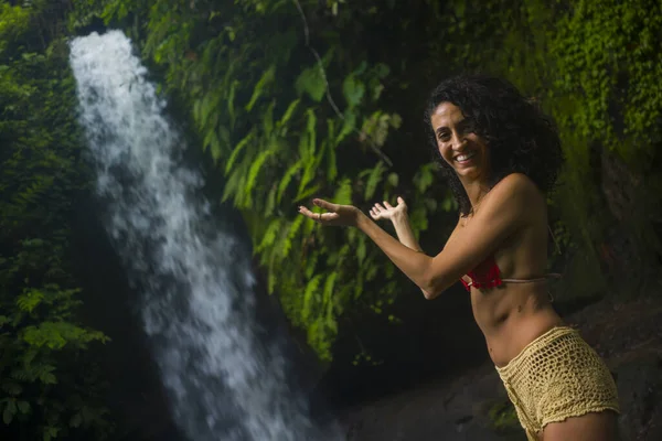 Outdoors lifestyle portrait of young attractive and happy hipster woman enjoying nature feeling free at amazing beautiful waterfall in exotic holidays travel destination — 스톡 사진