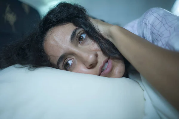Muda sedih dan depresi wanita hispanik dengan rambut keriting tidur di tempat tidur terjaga dan perasaan bijaksana khawatir menderita masalah depresi dan gangguan insomnia — Stok Foto