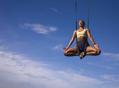 Hava yogası meditasyonu plaj egzersizi. Genç çekici ve sağlıklı bir kadın. Aero-yoga antrenmanı yapıyor. 