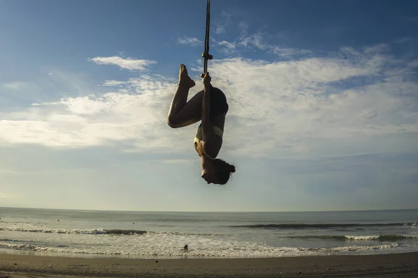 Letecká jóga meditace plážové cvičení izolované na modré obloze - silueta mladé atraktivní a zdravé ženy cvičit letecko-jóga trénink tělesné rovnováhy visí — Stock fotografie