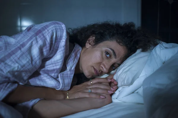 Dramatische Nacht Lebensstil Porträt der jungen traurigen und depressiven lateinischen Frau mit lockigem Haar schlaflos im Bett wach und nachdenklich Gefühl besorgt leiden Depressionen — Stockfoto