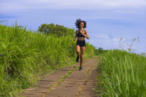 Entrenamiento de corredor femenino feliz en carretera rural - joven atractiva y en forma mujer corredor haciendo ejercicio al aire libre en pista hermosa en estilo de vida saludable y deporte —  Fotos de Stock