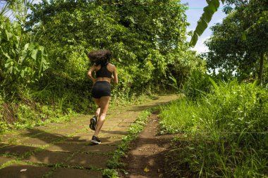 Kırsal yolda bayan koşucu eğitimi - genç çekici ve formda koşucu kadın dışarıda koşuyor sağlıklı yaşam tarzında güzel bir pistte.