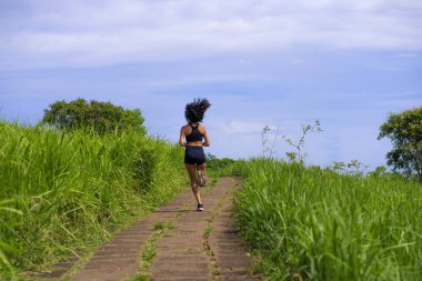 Kırsal yolda bayan koşucu eğitimi - genç çekici ve formda koşucu kadın dışarıda koşuyor sağlıklı yaşam tarzında güzel bir pistte.