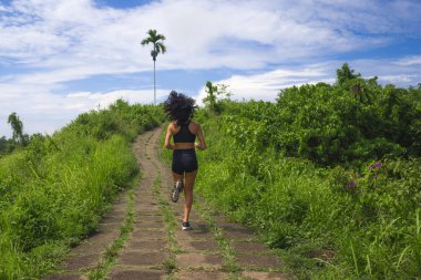 Kırsal yolda bayan koşucu eğitimi - genç çekici ve formda koşucu kadın dışarıda koşuyor sağlıklı yaşam tarzında güzel bir pistte.