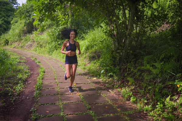 Glad kvinnliga löpare utbildning på landsbygden väg - ung attraktiv och passform jogger kvinna gör löpning träning utomhus på vackra spår i hälsosam livsstil och sport — Stockfoto