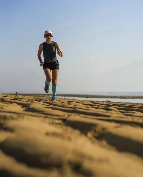 Potret gaya hidup kebugaran luar ruangan dari wanita muda yang atraktif dan atletis dalam kompresi berlari kaki jogging di pantai melakukan latihan interval dalam konsep pelatihan atlet — Stok Foto