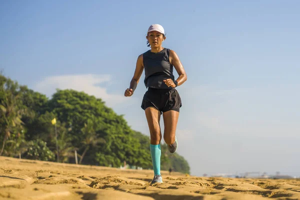 Outdoors fitness lifestyle portrait of young attractive and athletic woman in compression running socks jogging on the beach doing intervals workout in athlete training concept — ストック写真