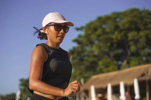 Outdoors fitness lifestyle portrait of young attractive and athletic woman jogging happy on city park doing intervals workout in athlete training a running session — Stok fotoğraf