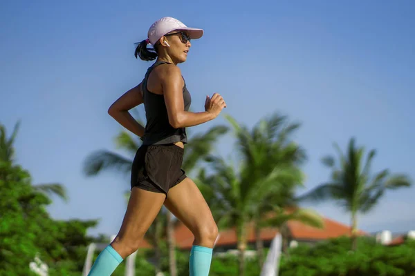 Outdoors fitness portrait of young attractive and athletic woman jogging happy on city park doing intervals workout training a running session concept in athlete healthy lifestyle — Stockfoto