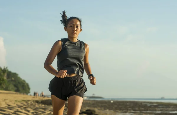 40 'larında Endonezyalı genç ve çekici bir Endonezyalı kadının açık hava fitness portresi. Sahilde koşuyor. Atletizm konseptinde antrenman yapıyor. — Stok fotoğraf