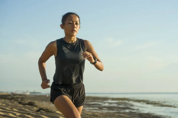 Ao ar livre fitness retrato de jovem atraente e atlético mulher indonésia asiática em seus 40 anos correndo na praia fazendo intervalos treino no conceito de treinamento de atleta — Fotografia de Stock