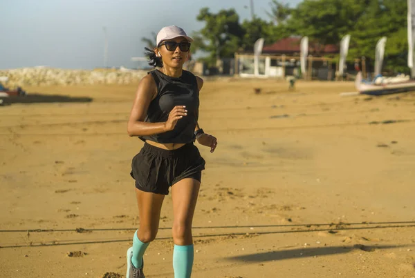 Glad asiatisk indonesisk kvinna i 40-årsåldern kör glad på stranden njuter morgon jogging träning glad och bekymmerslös i professionell idrottare träningskoncept — Stockfoto