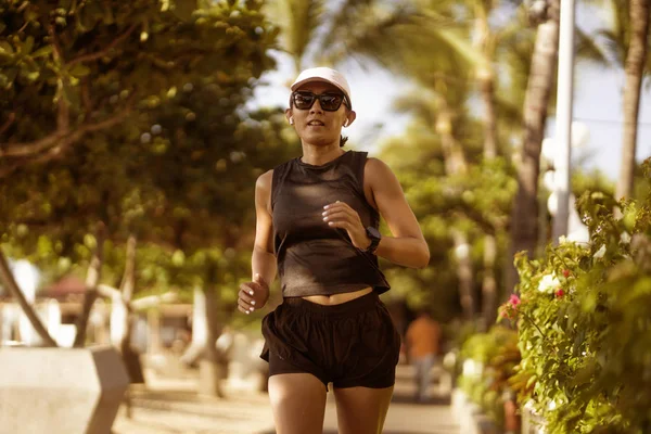 Potret kebugaran luar ruangan wanita muda yang atraktif dan atletis Indonesia berusia 40-an menjalankan pelatihan bahagia di taman kota melakukan latihan pagi dalam gaya hidup pelari — Stok Foto