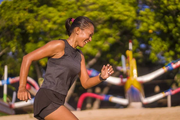 Utomhus fitness porträtt av ung attraktiv och atletisk asiatisk indonesisk kvinna i 40-årsåldern kör glad träning i stadsparken gör morgonträning i löpare livsstil — Stockfoto