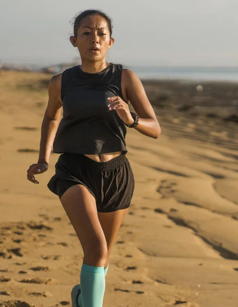 Γυμναστήριο σε εξωτερικούς χώρους πορτρέτο των νέων ελκυστική και αθλητική ασιατική ινδονησιακή γυναίκα στα 40 της τρέχει στην παραλία κάνει διαλείμματα προπόνηση στην έννοια προπόνηση αθλητή — Φωτογραφία Αρχείου