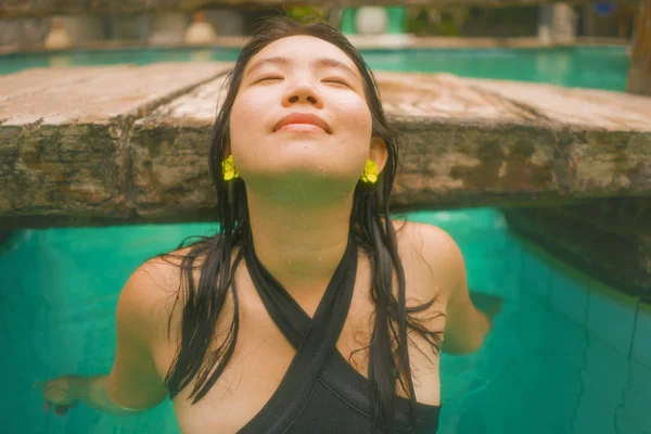 Vacaciones estilo de vida retrato de la joven hermosa y feliz mujer coreana asiática en bikini disfrutando de viaje de vacaciones relajado y dichoso en la piscina tropical resort en concepto de turismo exótico — Foto de Stock