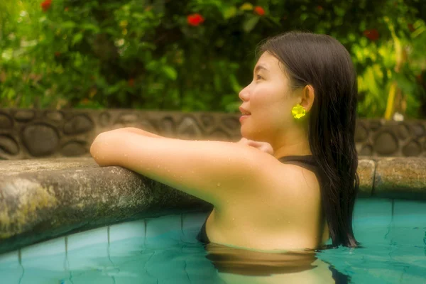 Vacaciones estilo de vida retrato de la joven hermosa y feliz mujer china asiática en bikini disfrutando de viaje de vacaciones relajado y dichoso en la piscina tropical resort en concepto de turismo exótico —  Fotos de Stock