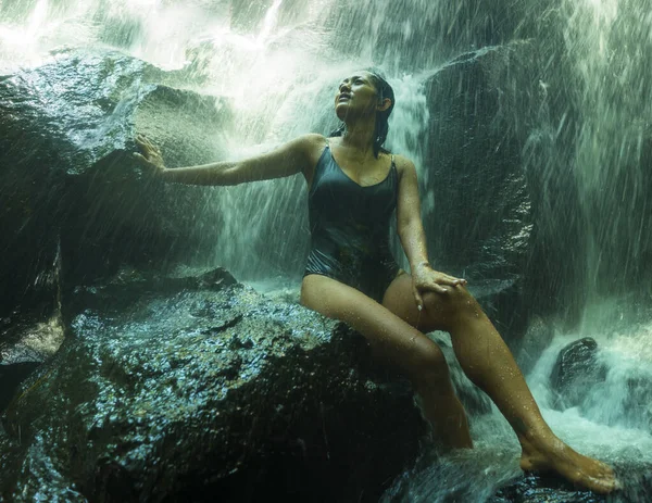 Junge attraktive und glückselige asiatische Indonesierin überwältigt von der Schönheit des natürlichen Wasserfalls im tropischen Dschungel und genießt glücklich das erstaunliche und exotische Reiseziel — Stockfoto