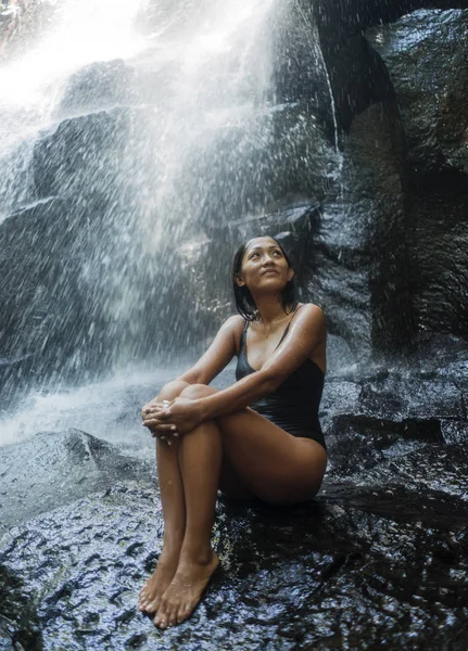 Jovem atraente e feliz mulher indonésia asiática oprimida pela beleza da cachoeira natural na selva tropical desfrutando feliz o destino de viagem incrível e exótico — Fotografia de Stock