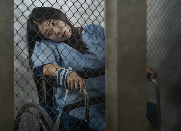 Irrenanstalt Horrorfilm Porträt einer jungen kranken und psychotischen asiatischen Chinesin, die isoliert und im Rollstuhl sitzend in der Sicherheitszelle eines psychiatrischen Krankenhauses eingesperrt ist — Stockfoto