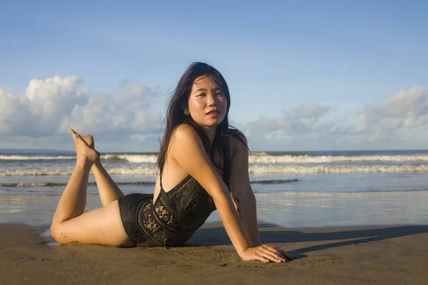在美丽的海滩天堂里 身穿游泳衣的年轻迷人而快乐的亚裔日本女人穿着游泳衣在沙滩上嬉闹玩耍 感觉放松而快乐 享受无忧无虑的假期 — 图库照片