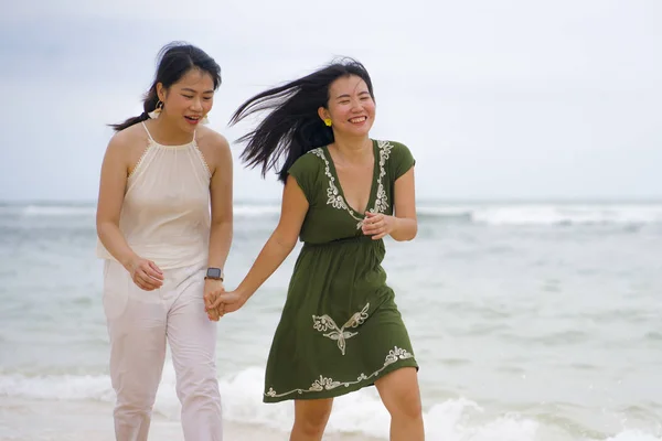 年轻漂亮而快乐的一对年轻漂亮而又有魅力的亚裔中国女人一起散步在海滩上放松放松地享受假期在女孩的友谊理念中享受快乐自由的感觉 — 图库照片