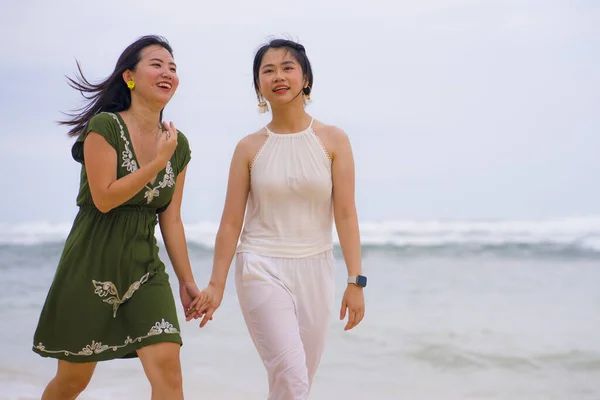 年轻美丽而快乐的一对年轻漂亮而又有魅力的亚裔韩国女性在海滩上散步时放松了下来 享受着同性恋情爱或亲密女友关系的假期 — 图库照片