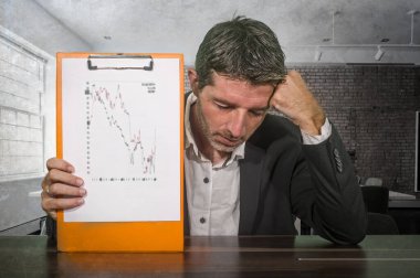 Depresyondaki ve endişeli iş adamı elinde grafik raporlama şirketi finansal krizini ve kurumsal iş sıkıntıları kavramında endişeli ve hayal kırıklığına uğramış sorunları gösteriyor.