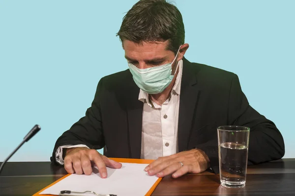 health organization executive man in medical face mask giving information at press conference about virus outbreak showing clipboard with epidemic disease spread warning about pandemic