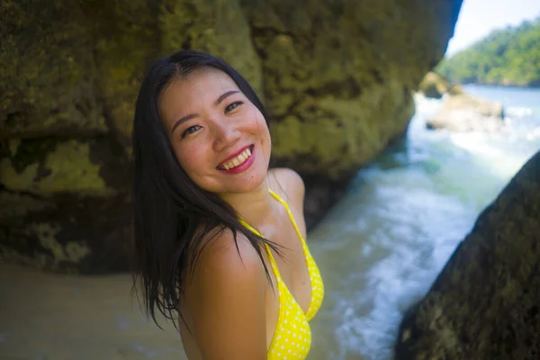 若いです幸せと美しいアジアの中国人女性の屋外の肖像黄色ビキニで楽しい休日を持っていることに興奮パラダイスビーチ島で遊ぶ海で牧歌的な旅行先を楽しんで — ストック写真