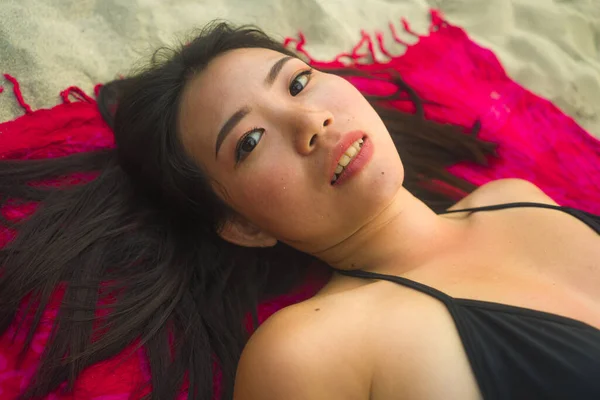 穿着比基尼的年轻 快乐的亚裔中国女人平躺在沙滩上的沙隆上 笑容满面 沉醉在美感和时尚的观念中 — 图库照片