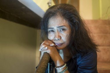 50 'lerin dramatik kadın portresi merdivenlerde depresif, üzgün ve yalnız bir kadın depresyonda ve orta yaş bunalımında. Merdivenlerde oturuyor ve umutsuz.